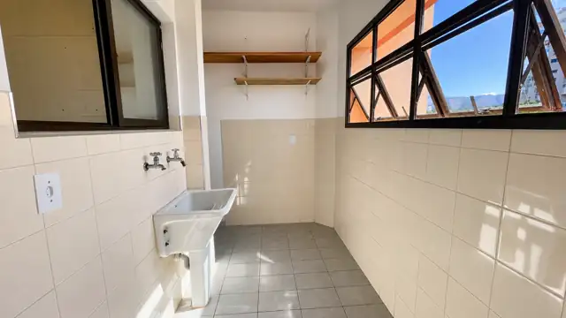 Área de serviço com tanque, prateleiras e janelas