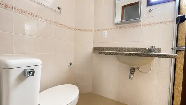 Banheiro social com bancada em granito e espelho