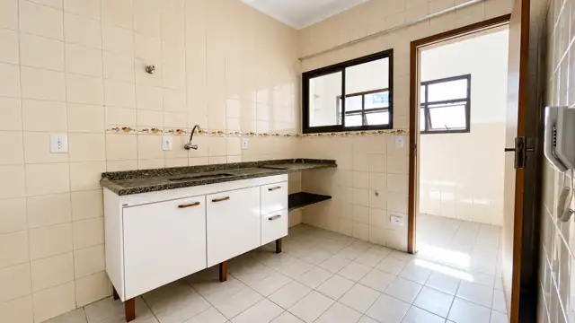 Cozinha funcional com bancada em granito e armários brancos