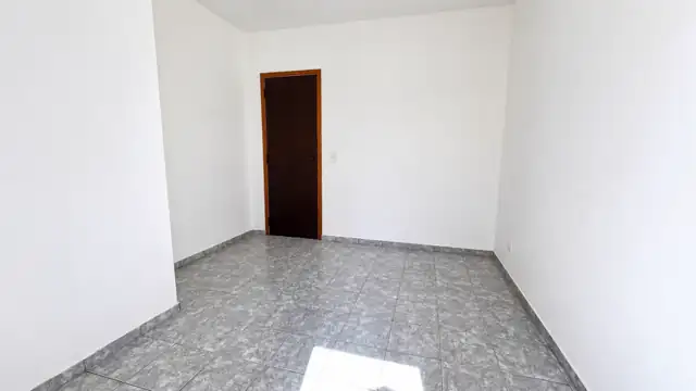 Dormitório com porta em madeira e paredes claras