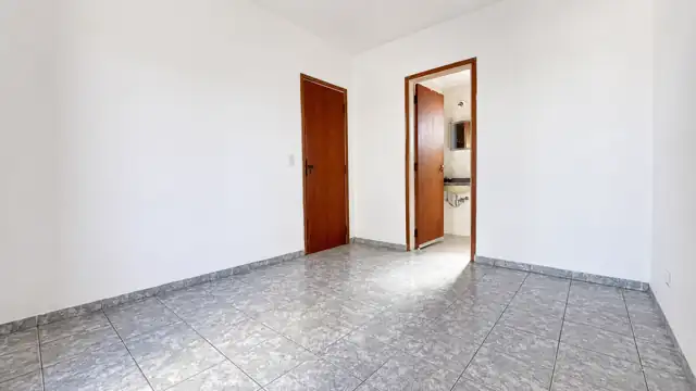 Dormitório da suíte com porta do banheiro ao fundo