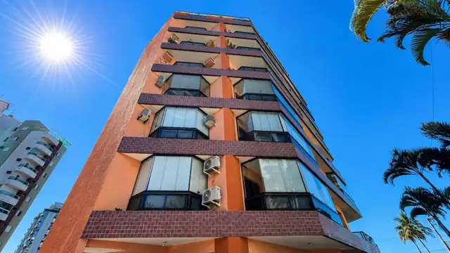Fachada do prédio do apartamento vista de baixo, com céu azul