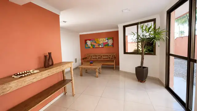 Hall de entrada do prédio com bancos de madeira e decoração