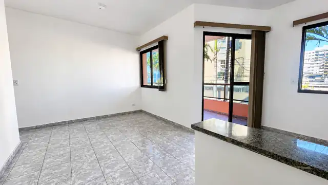 Sala com balcão em granito e acesso para a varanda