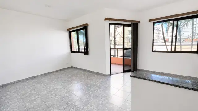 Sala com balcão em granito, janelas e porta para a varanda