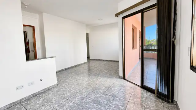 Sala com porta de vidro que dá acesso à varanda