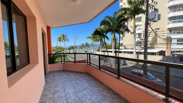 Varanda com guarda-corpo de vidro e a orla do Indaía ao fundo