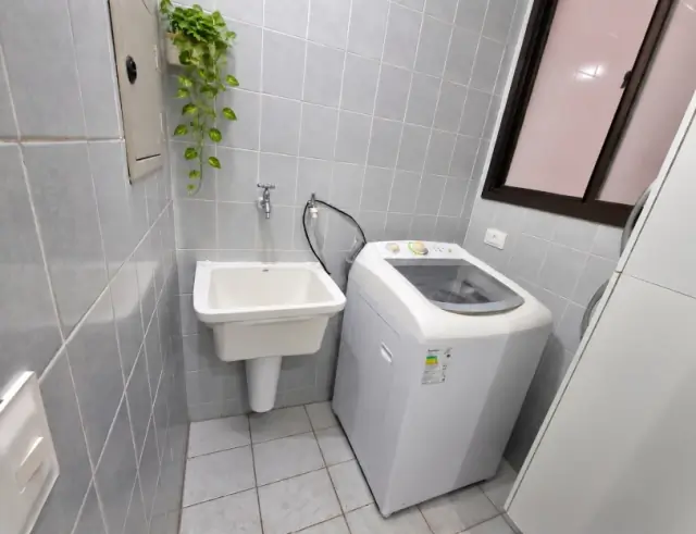 Área de serviço com tanque, máquina de lavar roupa e azulejos