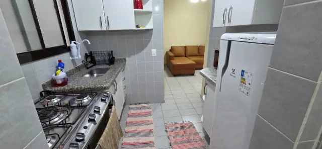 Bancada em granito com cooktop a gás, cuba e geladeira