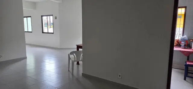 Salão de jogos e festas do condomínio com piso cerâmico e janelas