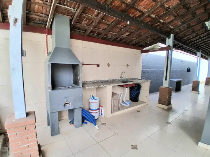 Bancada de apoio no espaço gourmet e corredor lateral coberto
