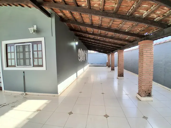 Varanda coberta ampla com colunas de tijolinho à vista