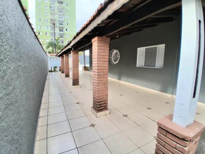 Extensa varanda lateral coberta em piso cerâmico