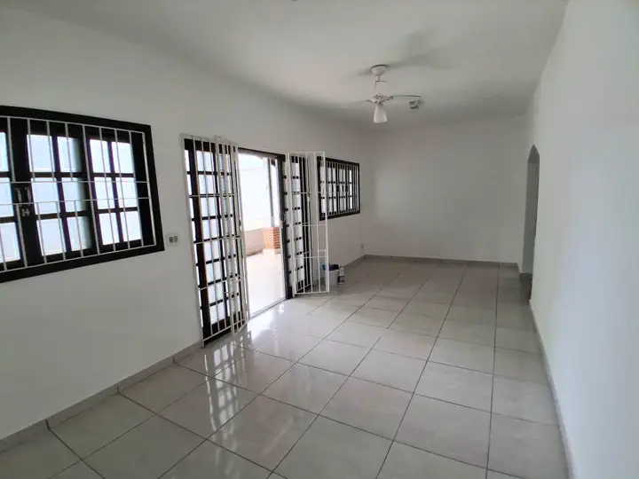 Sala de estar ampla e iluminada com porta dupla e janelas grandes