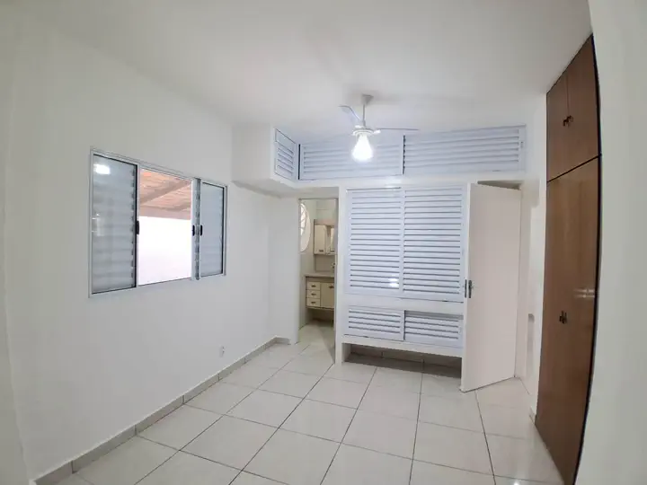 Vista completa da suíte com janela para a varanda e ventilador de teto