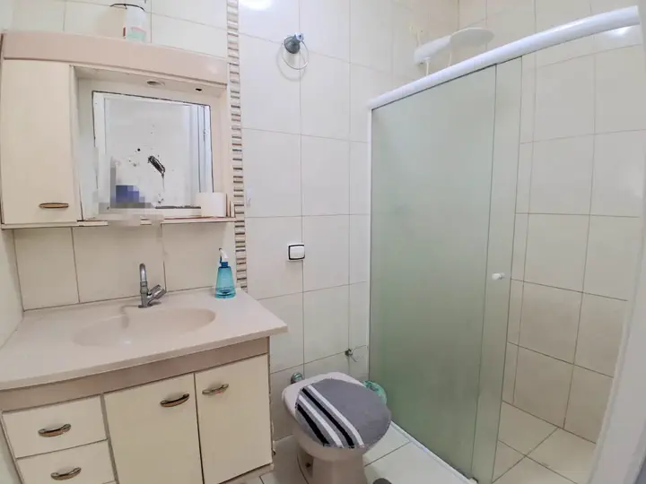 Banheiro da suíte completo com box de correr e chuveiro elétrico