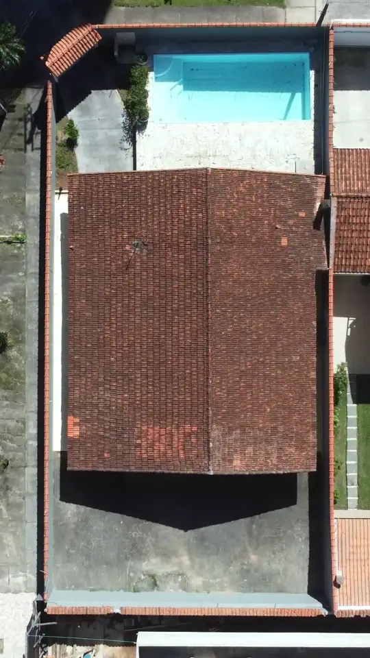 Vista aérea de cima mostrando o telhado da casa, piscina e quintal
