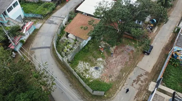 Vista aérea da esquina murada e da rua do bairro