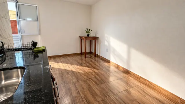 Cozinha com bancada em granito e porta para o quintal