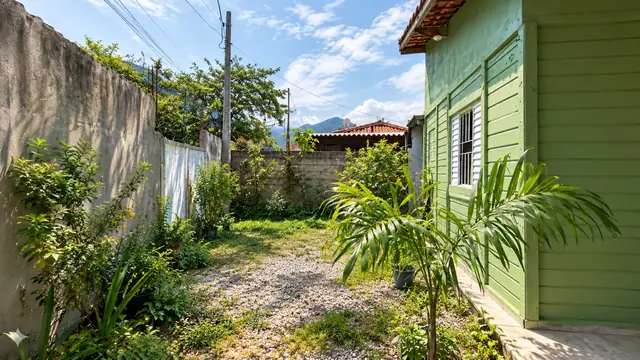 Lateral da casa com jardim e mureta