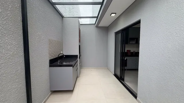 Área de serviço com tanque e acesso por porta de vidro