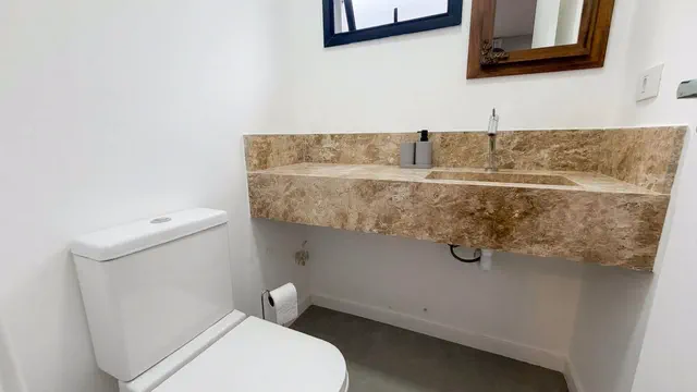 Banheiro social com bancada em granito e espelho