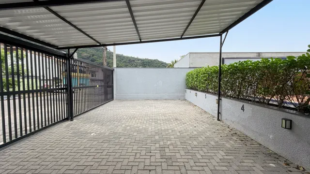 Garagem coberta e portão de acesso do sobrado