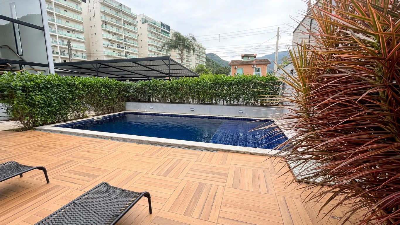 Piscina do Condomínio Talismã, com deck de madeira e espreguiçadeiras