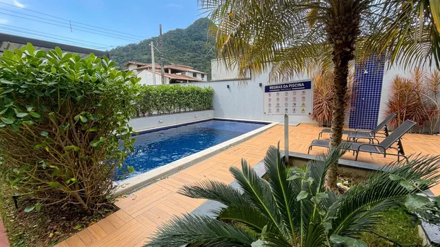 Piscina do condomínio cercada por palmeiras e montanhas