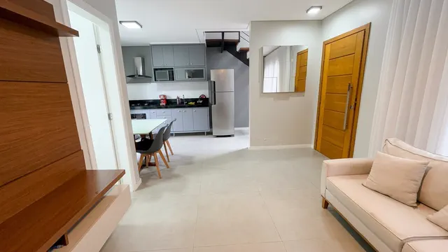 Sala de estar com painel de madeira, aparador e piso claro