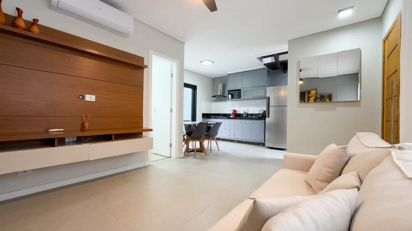 Sala integrada à cozinha do sobrado no Condomínio Talismã, com sofá e mesa de refeições