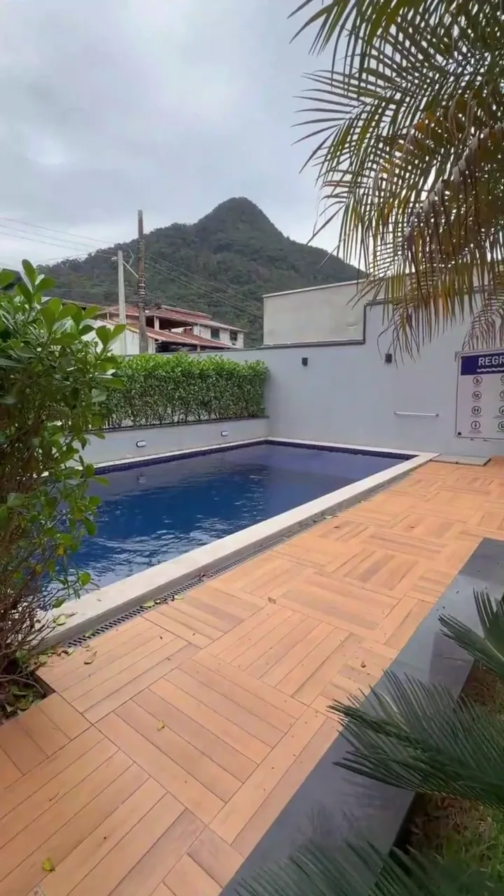 Piscina do Condomínio Talismã vista do deck, com a serra de Caraguatatuba ao fundo