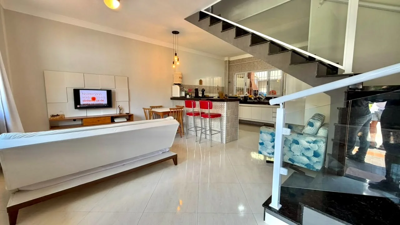 Sala com escada e cozinha ao fundo